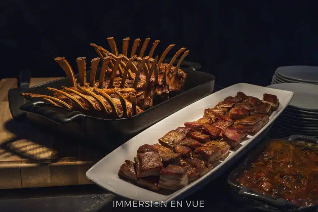 A variety of barbecue ribs and sliced meats served at a catering food station during the opening reception of a corporate conference
